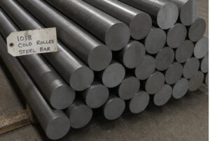 A stack of AISI 1018 cold rolled steel round bars bundled in an industrial warehouse setting, featuring a metal tag denoting the steel grade for precision machining and manufacturing applications.